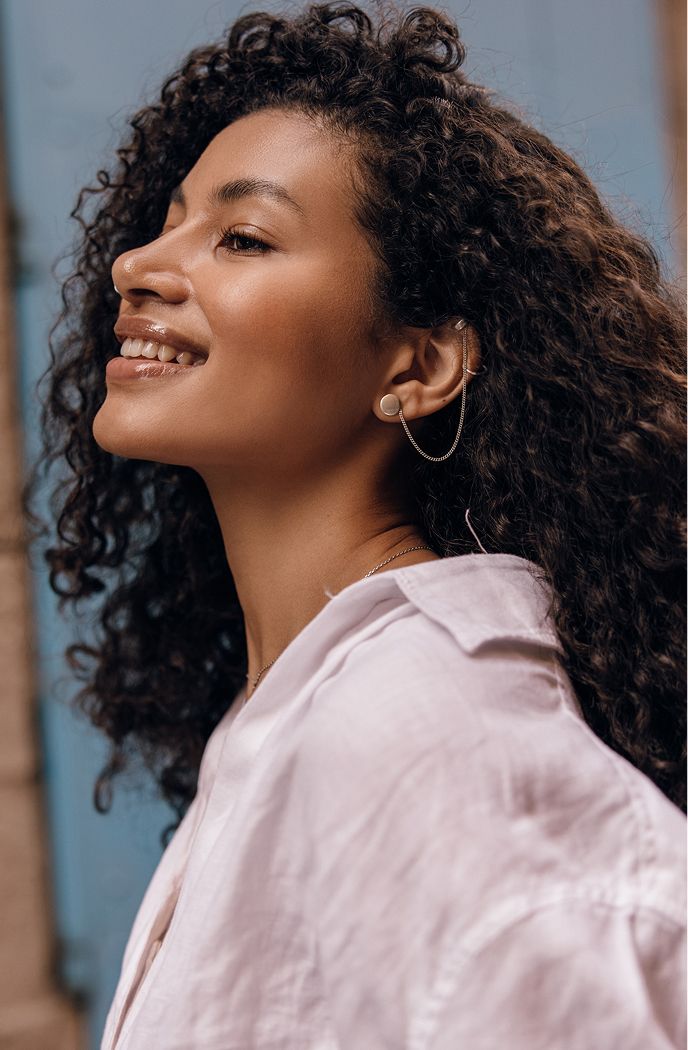 Woman with curly hair and playful expression.