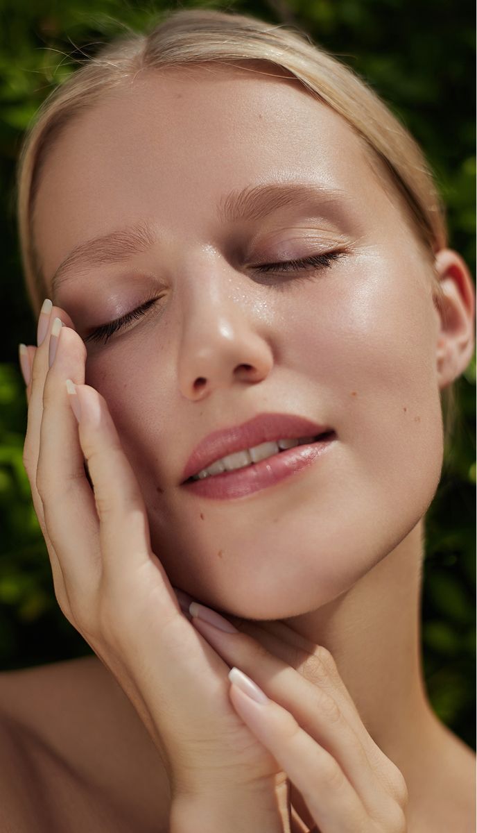 Close-up of a woman with glowing skin.