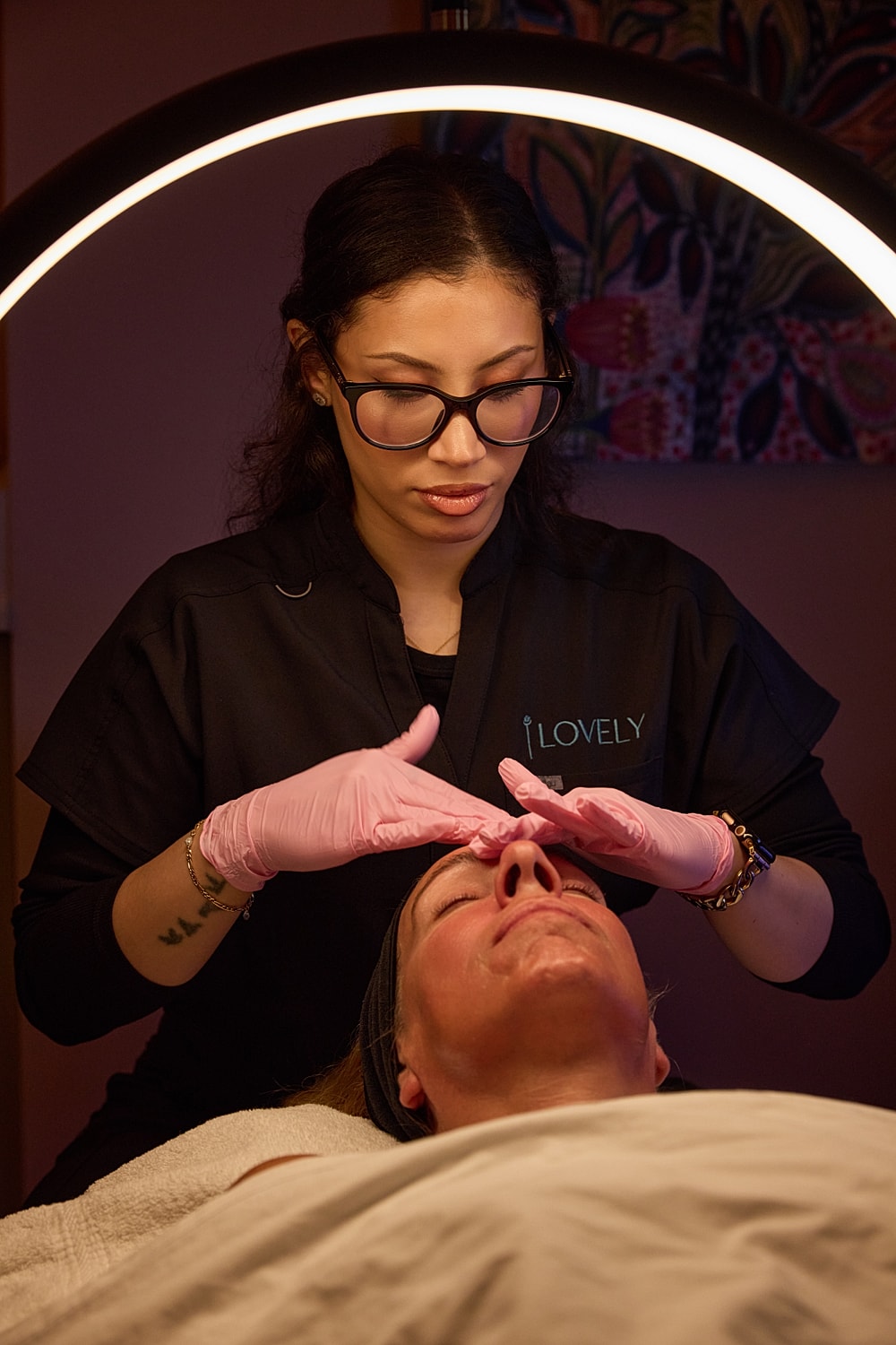 Esthetician performing facial treatment on client.