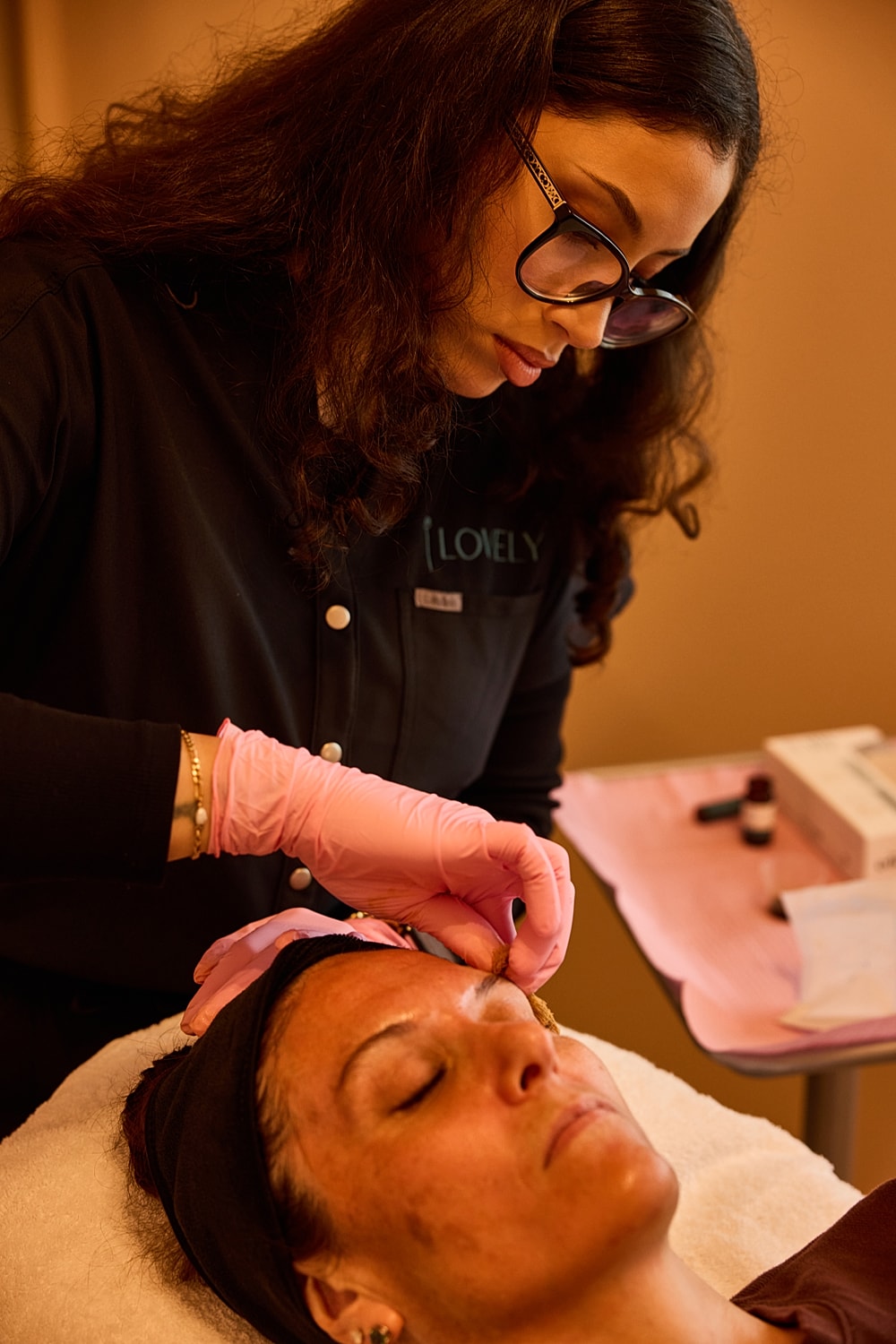 Esthetician performing a facial treatment on client.