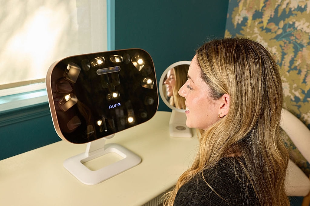 Woman using a beauty mirror with lighting.