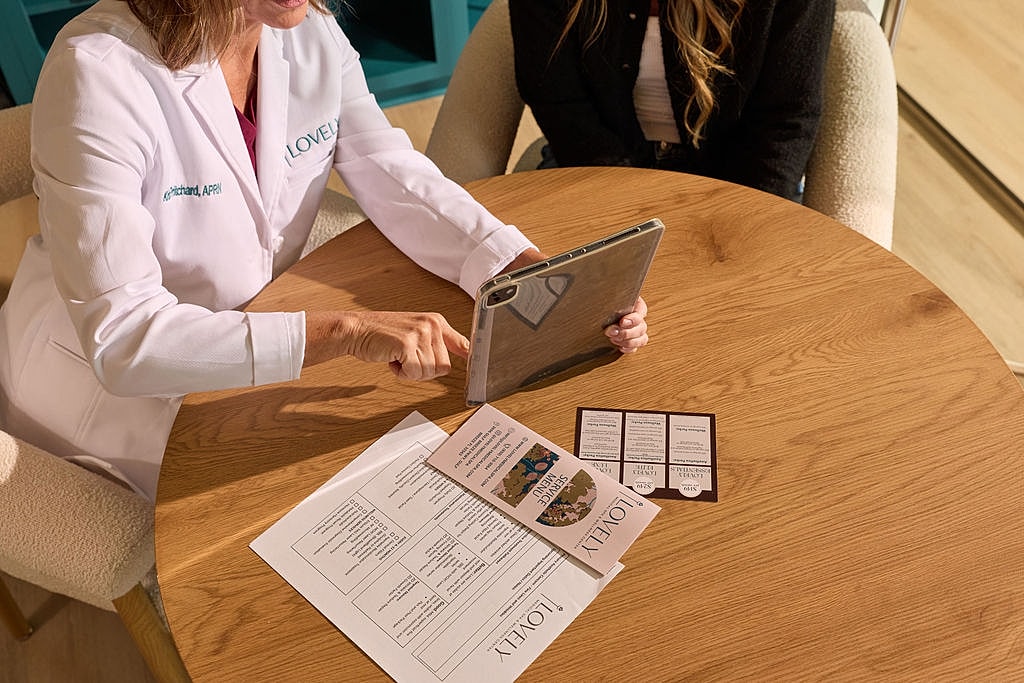 Medical professional consulting with patient at table.