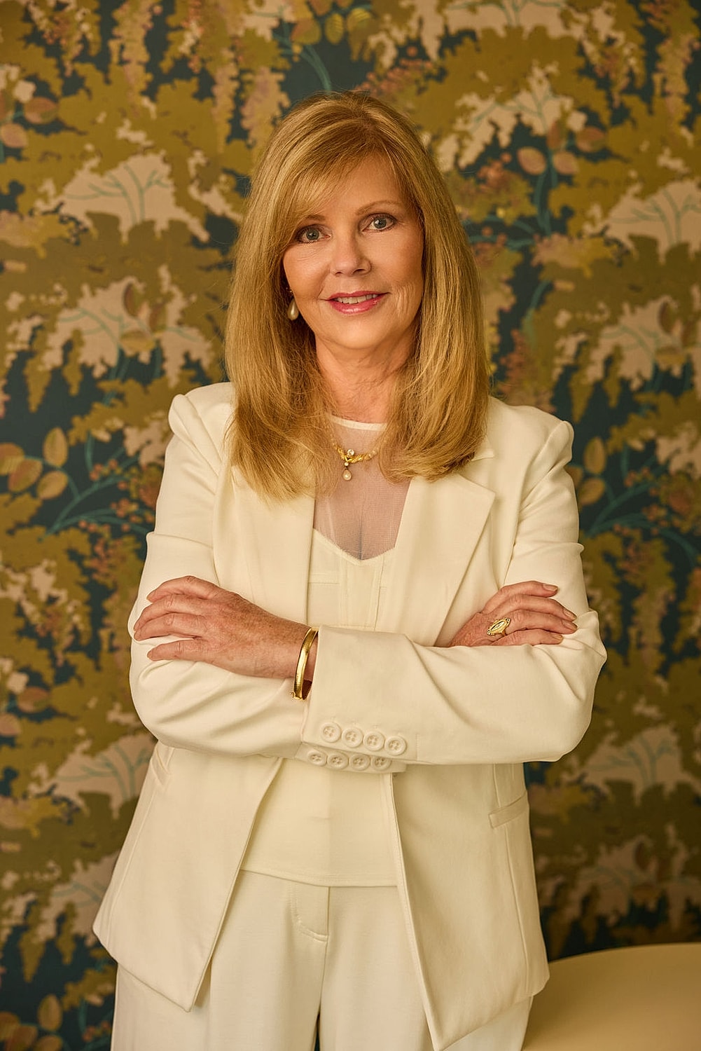 Smiling woman with long hair on pink background.