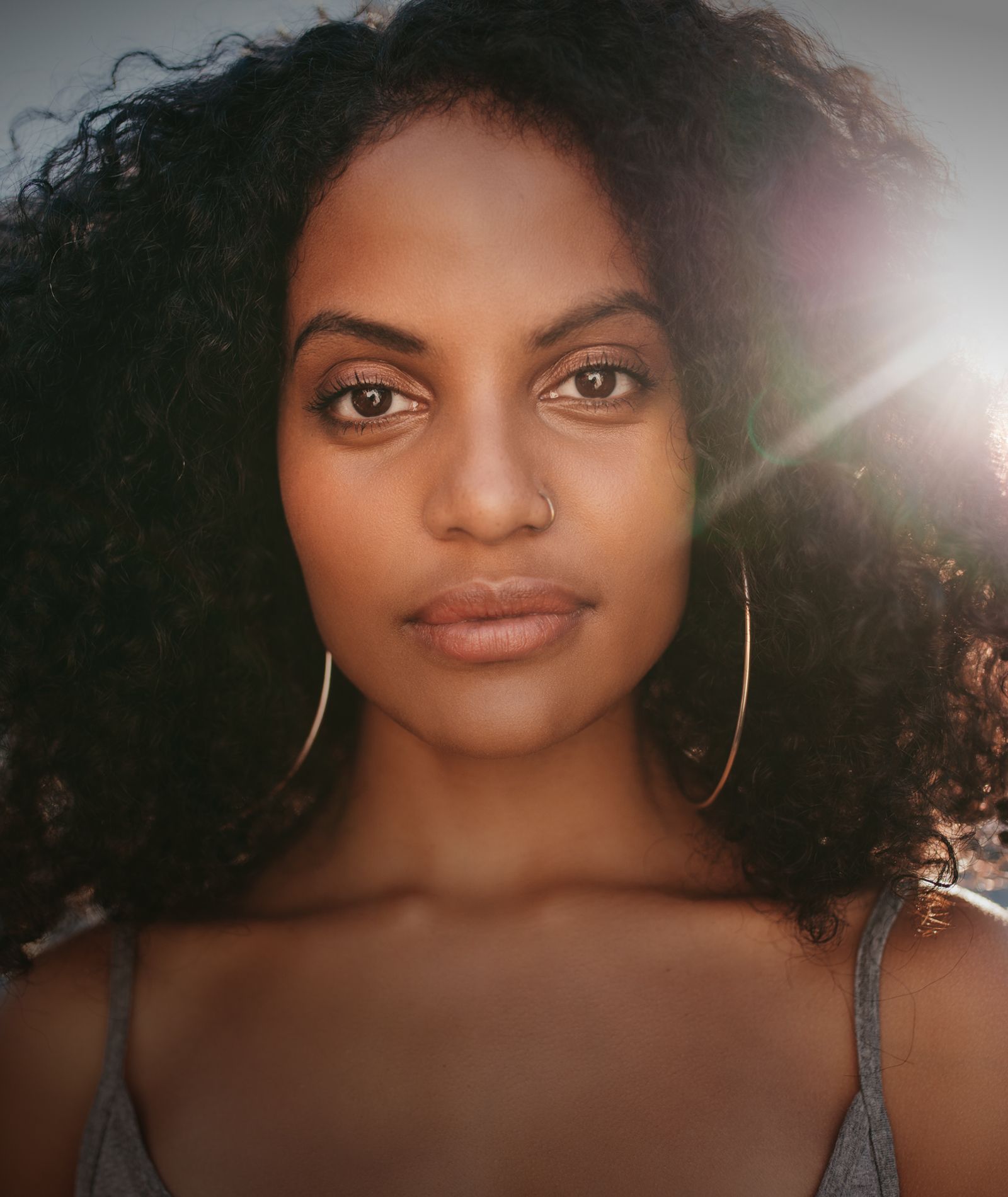 Woman with curly hair and hoop earrings.