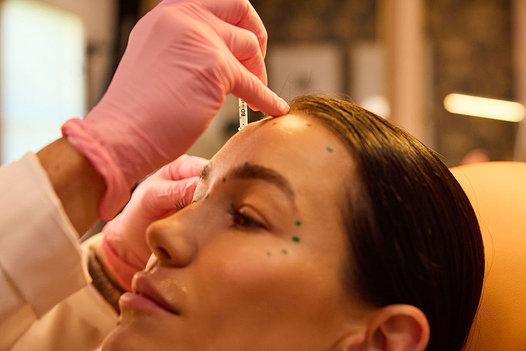 Smiling woman with long dark hair indoors.