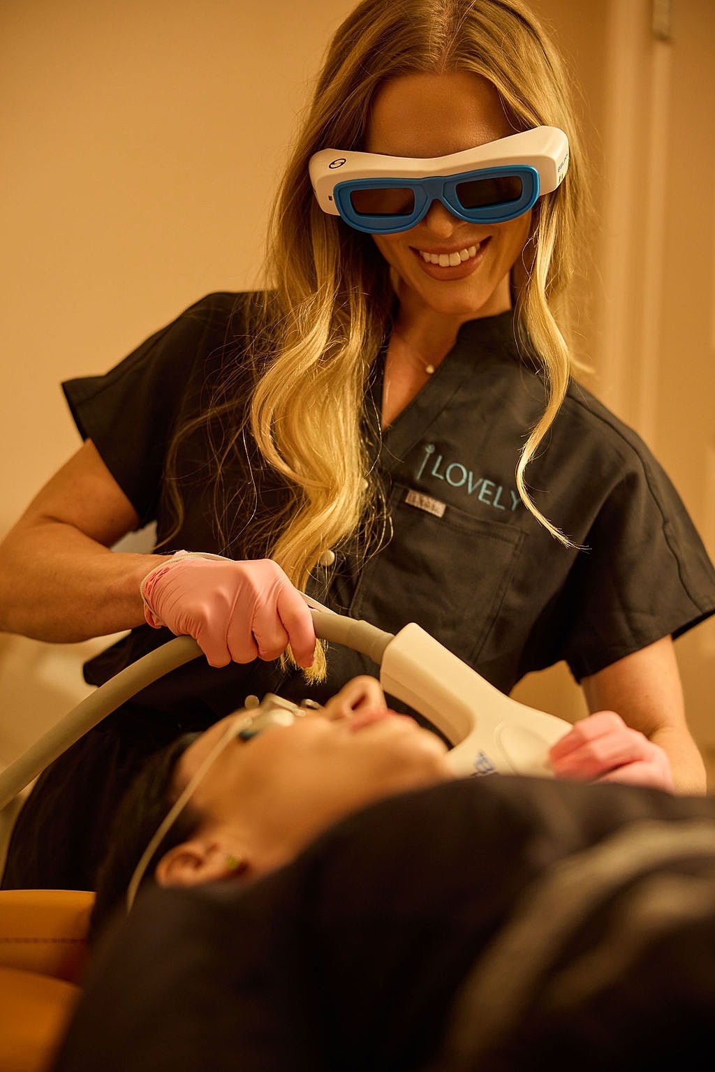 Smiling woman in straw hat against wooden background.
